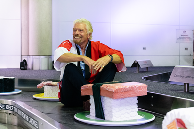 Sir Richard Branson lives out a childhood dream, riding the baggage belt.