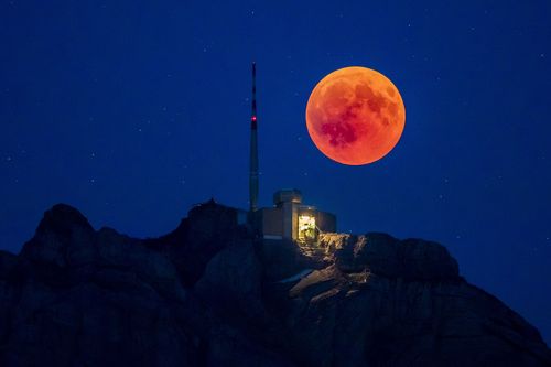 The blood moon rises behind the Saentis Alpstein, Canton of Appenzell, Switzerland. Picture: AAP