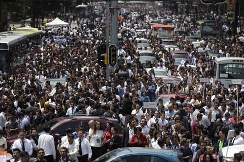 People evacuated from office buildings gather in Reforma Avenue. (AP)