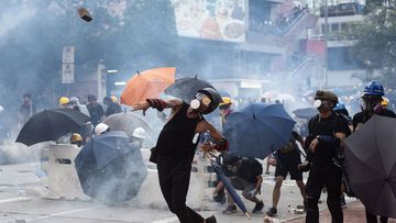 Anti-extradition protesters throw bricks as others react after police fired tear gas at them during clashes in Wong Tai Shin area in Hong Kong.
