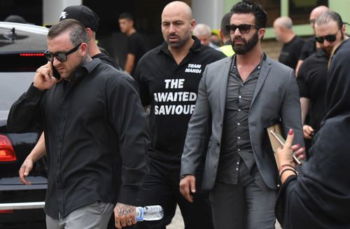 Mourners, with tattoos seen poking out from collars and sleeves, leave the mosque in Arncliffe. (AAP)