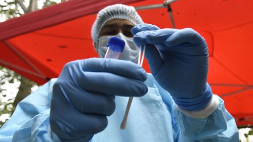 A health worker collects a swab sample for COVID-19 test.