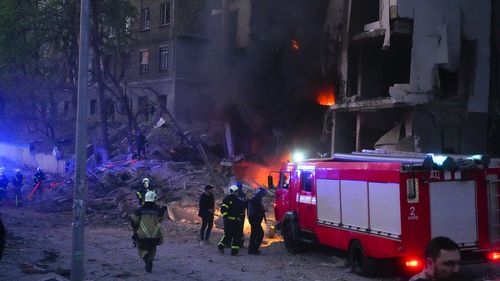 Firefighters put out a fire after a Russian rocket attack in Kyiv, Ukraine, Thursday, April 28, 2022. Russia mounted attacks across a wide area of Ukraine on Thursday, bombarding Kyiv during a visit by the head of the United Nations. (AP Photo/Efrem Lukatsky)