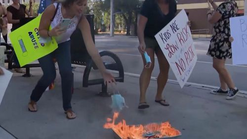 Demonstrators in the US burn face masks in protest against the COVID-19 vaccine.