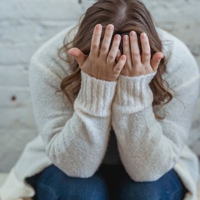 Woman with her head in her hands stock photo.