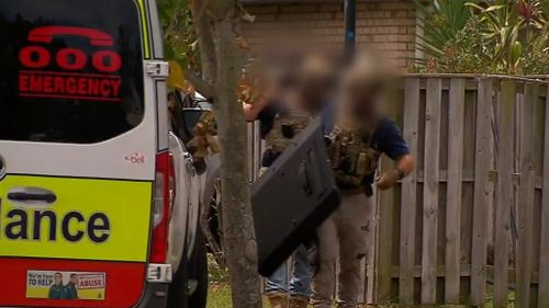 Residents of a Gold Coast street have been forced to spend hours shut inside their home as specialist police swarmed a property. 