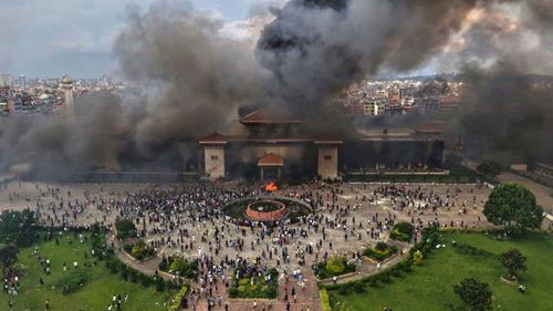 Os manifestantes comemoram no prédio do Parlamento depois que ele foi incendiado durante um protesto contra a proibição da mídia social e a corrupção em Katmandu, Nepal