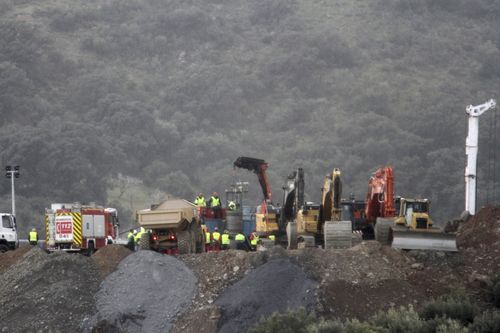 Drill machines and excavating machinery work on top of the mountain next to a deep borehole to reach a trapped boy Totalan in Malaga, Spain.