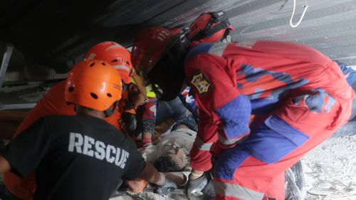 Rescuers pull out a survivor from a collapsed building at an Islamic boarding school in Sidoarjo, East Java, Indonesia, Monday, Sept. 29, 2025. (AP Photo/Trisnadi)