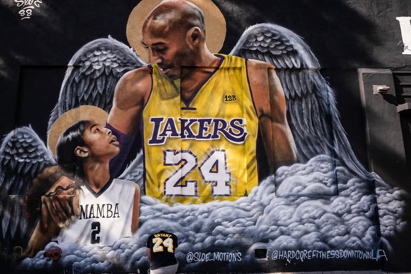 Adam Dergazarian, bottom center, pays his respects for Kobe Bryant and his daughter, Gianna, in front of a mural painted by artist Louie Sloe Palsino in Los Angeles. (AP Photo/Jae C. Hong, File)