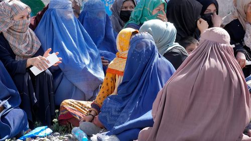 Le donne afghane aspettano di ricevere razioni di cibo distribuite da un gruppo di aiuti umanitari saudita a Kabul, in Afghanistan, il mese scorso.