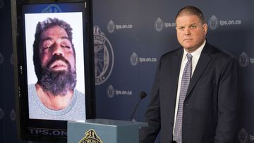 Det. Hank Idsinga, lead investigator in the case against Bruce McArthur, stands with a photo of an unidentified man. (AP)