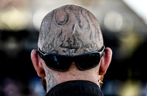 A heavily tattooed man is seen enjoying the neo-Nazi festival. (AAP)