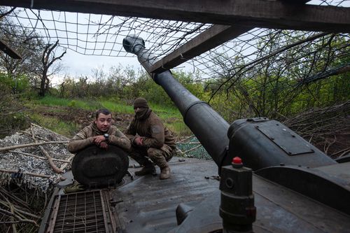 Ukrainian soldiers sit near a self-propelled howitzer in Chasiv Yar, the site of heavy battles with the Russian forces in the Donetsk region.