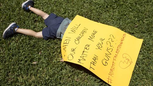 Three-year-old Remy Ragsdale holds a sign at a gun control protest at the Governor's Mansion in Austin, Texas.