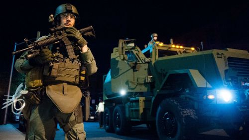 Police and National Guardsmen patrol the intersection of Cumberland and Pennsylvania Avenue in Baltimore. (AAP)