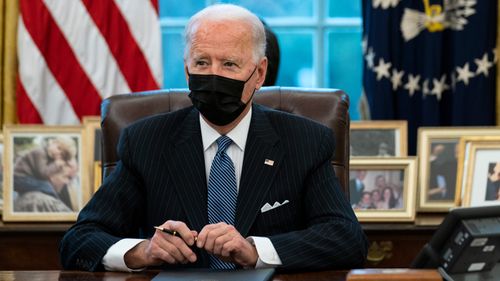 President Joe Biden looks up after signing an Executive Order reversing the Trump era ban on transgender individuals serving in military, in the Oval Office of the White House