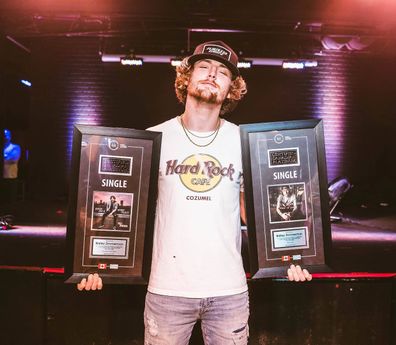 Bailey Zimmerman poses with his certified platinum singles.