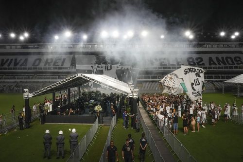 Les fans de football applaudissent en rendant un dernier hommage au regretté footballeur brésilien Pelé lors de son réveil au stade Vila Belmiro de Santos, au Brésil, tôt le mardi 3 janvier 2023 