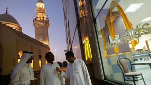 Men walk past a McDonald's as they leave a prayer session in a mosque in Manama, Bahrain.