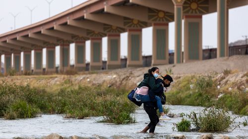   Des immigrants traversent le Rio Grande pour demander l'asile à El Paso, au Texas, le 18 décembre 2022 depuis Ciudad Juarez, au Mexique. 