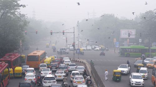Vehicles wait at a crossing amidst morning smog in New Delhi, India.