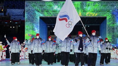 FILE- Olga Fatkulina and Vadim Shipachyov, of the Russian Olympic Committee, carry a flag into the stadium during the opening ceremony of the 2022 Winter Olympics, on Feb. 4, 2022, in Beijing, where Russian athletes competed under the acronym ROC, for Russian Olympic Committee, for the third time. Ukrainian President Volodymyr Zelenskyy, who has previously said any neutral flag for Russia would be stained with blood, is set to address a group of sports ministers meeting to discuss Russian partic