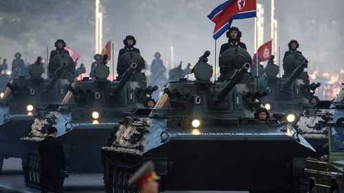 North Korean soldiers ride atop armoured vehicles during a mass military parade at Kim Il-Sung square in Pyongyang on October 10, 2015. 