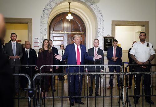 Former President Donald Trump, center, arrives for his civil business fraud trial at New York Supreme Court, Tuesday, Oct. 17, 2023, in New York. Trump's son, Eric Trump, stands at left.