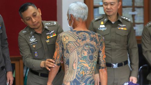 Japanese gang member Shigeharu Shirai displays his tattoos at a police station during a press conference in Lopburi, central Thailand, Thursday, Jan. 11, 2018. Thai police have arrested the 72-year-old fugitive who was recognized when his full-body tattoos were circulated online. A police statement says Shirai was arrested Wednesday in a province north of Bangkok, where he has been hiding for over 10 years to evade murder charges in Japan in connection with the death of a rival gang member. (AP Photo)