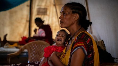 oman Kidanemariam, 35, holds her malnourished daughter, Merkab Ataklti, 22 months old, in the treatment tent of a medical clinic in the town of Abi Adi, in the Tigray region of northern Ethiopia. As the United States warns that up to 900,000 people in Tigray face famine conditions in the world's worst hunger crisis in a decade (AP Photo/Ben Curtis) 