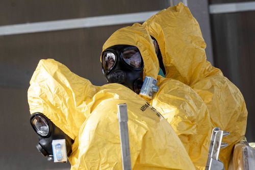 People in protective gear wait to enter a Boeing aircraft of the Italian Air Force with eight of the Italians who were stranded in Wuhan under quarantine measures to contain the coronavirus, at Mario De Bernardi military airport in Pratica di Mare, south of Rome, Italy.