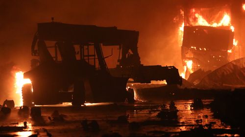 A fire rages at the BM Inland Container Depot, early Sunday, June 5, 2022. Dozens have been killed and more than 100 others injured in the fire the cause of which could not be immediately determined. (AP Photo)