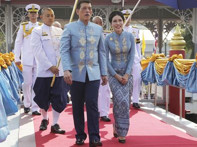 Thai King Maha Vajiralongkorn, center, and his royal noble consort Sineenat Wongvajirabhakdi, right, arrive at the Wasukri pier during a merit-making ceremony for her 36th birthday in Bangkok, Thailand, on Tuesday, Jan. 26, 2021. Thai royal noble consort Sineenat was born on Jan. 26, 1985 .(AP Photo)