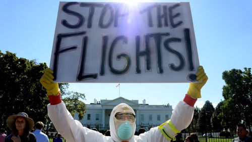 A demonstrator outside the White House calling for Mr Obama to ban flights from Africa. (AAP)