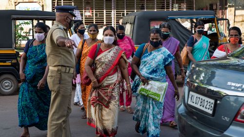 India has recorded more than 70,000 coronavirus cases in a single day.  Pictured are workers leaving the area after the Cochin Special Economic Zone that houses several industrial units was closed as part of COVID-19 containment measures in Kochi, Kerala, India.