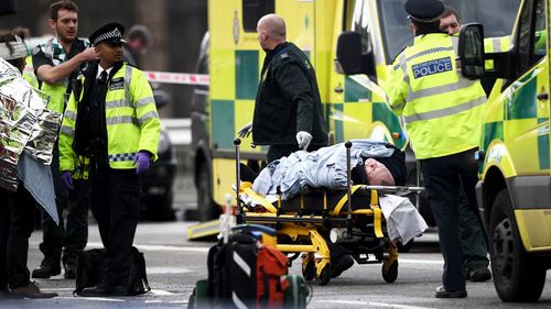 A person is taken away on a stretcher outside Westminster Palace. (Getty)