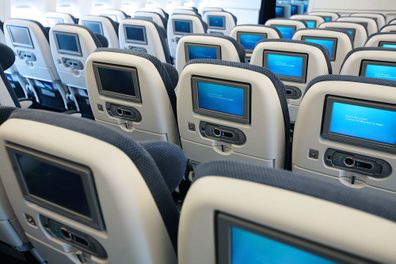 rows of seats on plane with entertainment screens