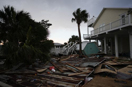 Debris from destroyed buildings lies next to a home still standing in Horseshoe Beach, Fla., after the passage of Hurricane Idalia, Wednesday, Aug. 30, 2023.  
