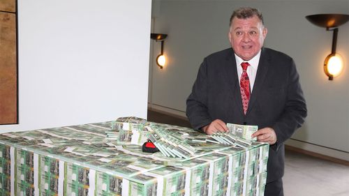 Independent MP Craig Kelly holding a fake 'trillion-dollar' note.