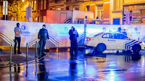 Police stand guard during raids in Brussels. (AAP)