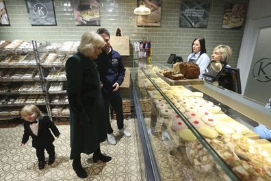 Fitzwilliam Corrie-Salmon photobombs the Queen as she visits Knotts Bakery in Belfast