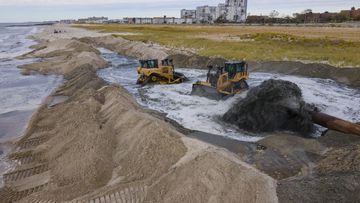 Contractors for the US Army Corps of Engineers pump sand from the ocean floor onto the beach in the Rockaway Peninsula in New York City on Tuesday, Oct. 18, 2022. 