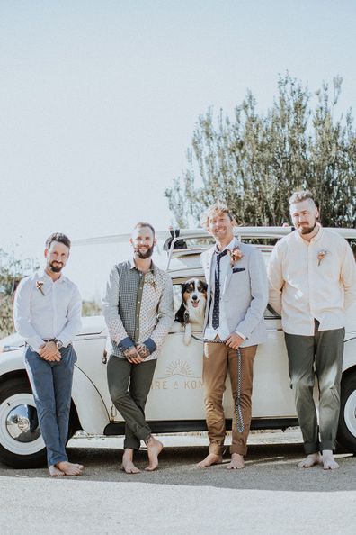 Australian bride and groom surf together before beach wedding