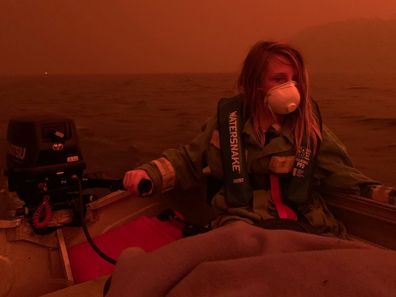 Finn Burns navigates a boat through thick smoke at Mallacoota, as fire advanced on the seaside Victorian town on December 31, 2019.