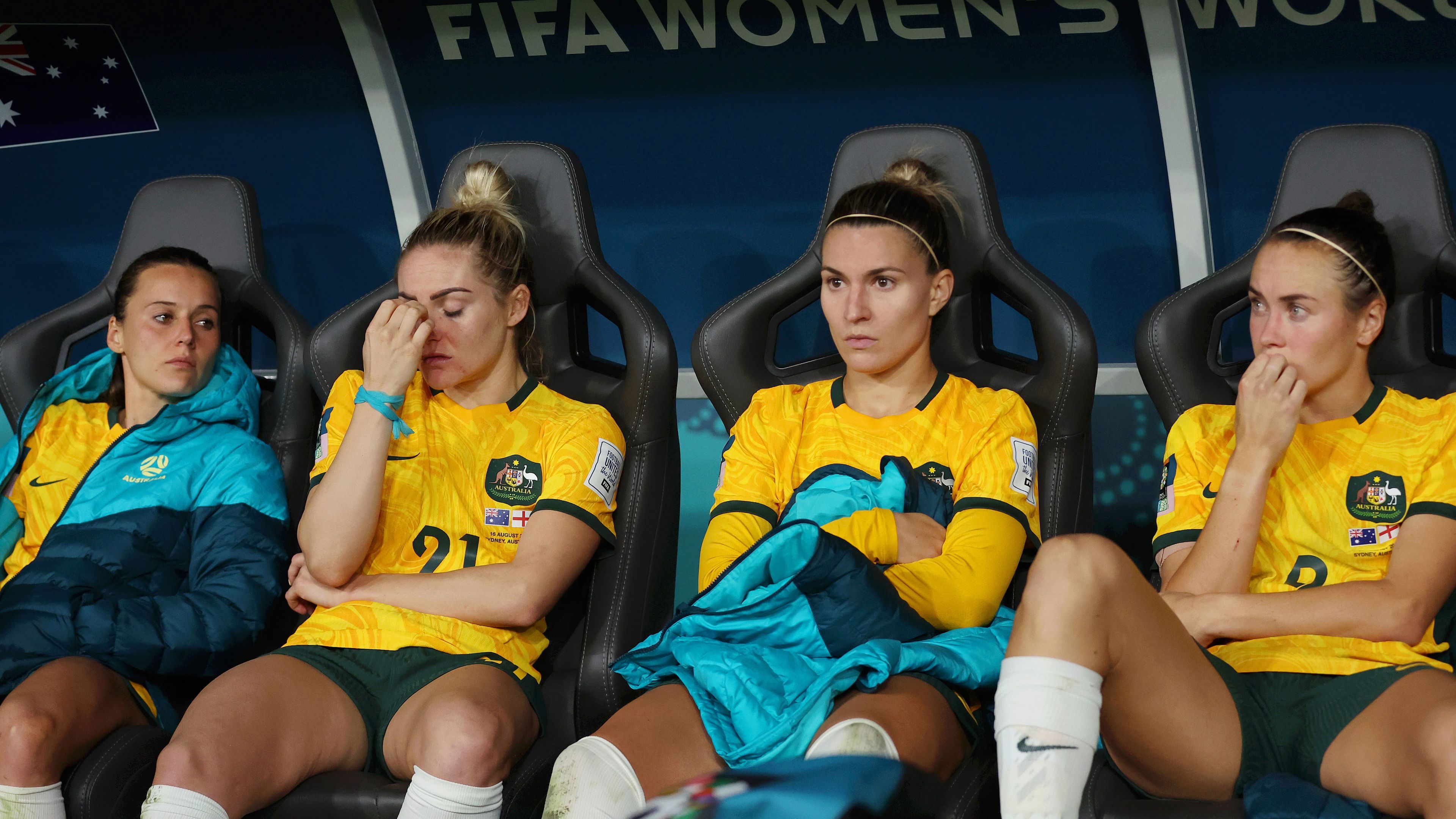 Ellie Carpenter, second from left, sinks her head in her hand as she reflects on the Matildas&#x27; loss to England alongside Hayley Raso (left), Steph Catley and Caitlin Foord.