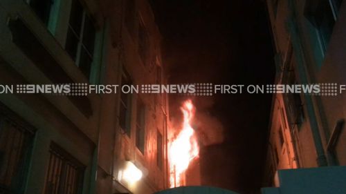 Flames escape a window at the property in Bondi. (9NEWS)