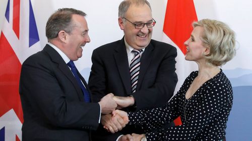 British Secretary of State for International Trade Liam Fox, Swiss Federal Councillor Guy Parmelin and Liechtenstein's Foreign Minister Aurelia Frick shake hands after signing a trade agreement in Bern, Switzerland.