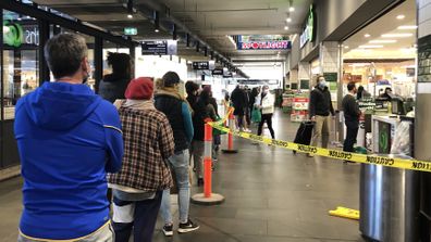A long queue forms outside Woolworths supermarket in South Melbourne