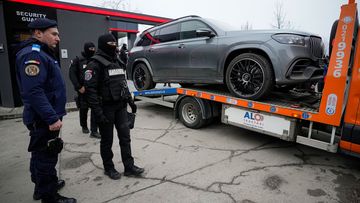 Gendarmes look as a luxury vehicle which was seized in a case against media influencer Andrew Tate, is towed away, on the outskirts of Bucharest, Romania.